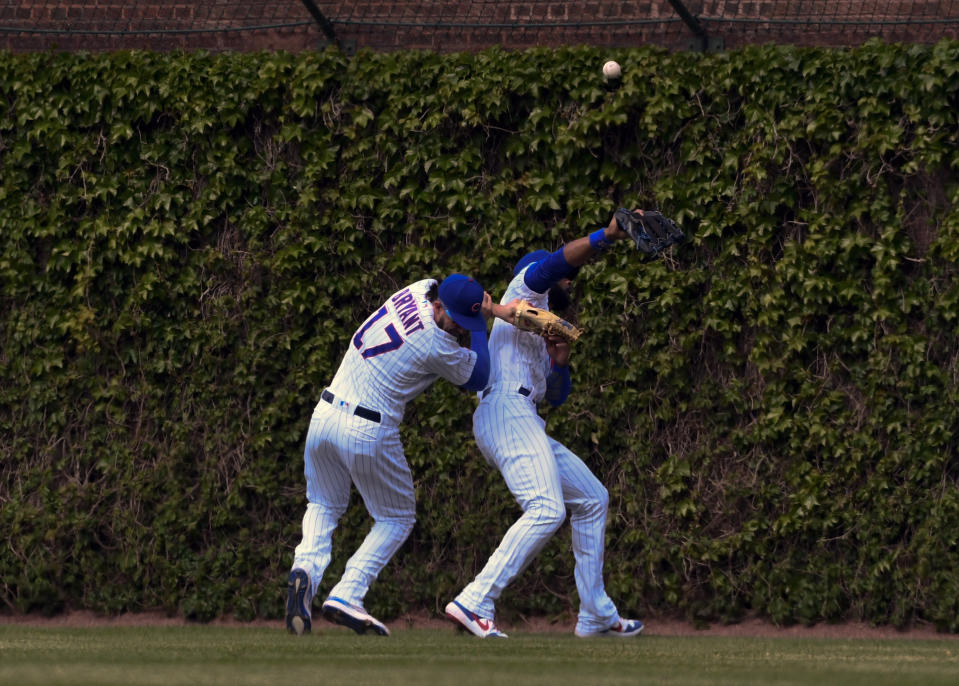 Chicago Cubs center fielder Jason Heyward, right, and right fielder Kris Bryant (17) collide while chasing a ball hit by Cincinnati Reds'c Eugenio Suarez (7) during the sixth inning of a baseball game Sunday, May 26, 2019, in Chicago. Bryant was charged with an error on the play. (AP Photo/Matt Marton)