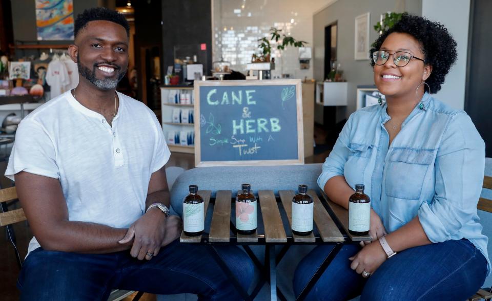 Rob Williams and Lauren Thompson-Williams sit at a Cane & Herb pop up stand at Stock & Belle, 387 South Main Street, on Saturday, Feb. 5, 2022, in Memphis, Tenn. Williams and Thompson-Williams co-own Cane & Herb, a Memphis-based company that creates simple syrups.