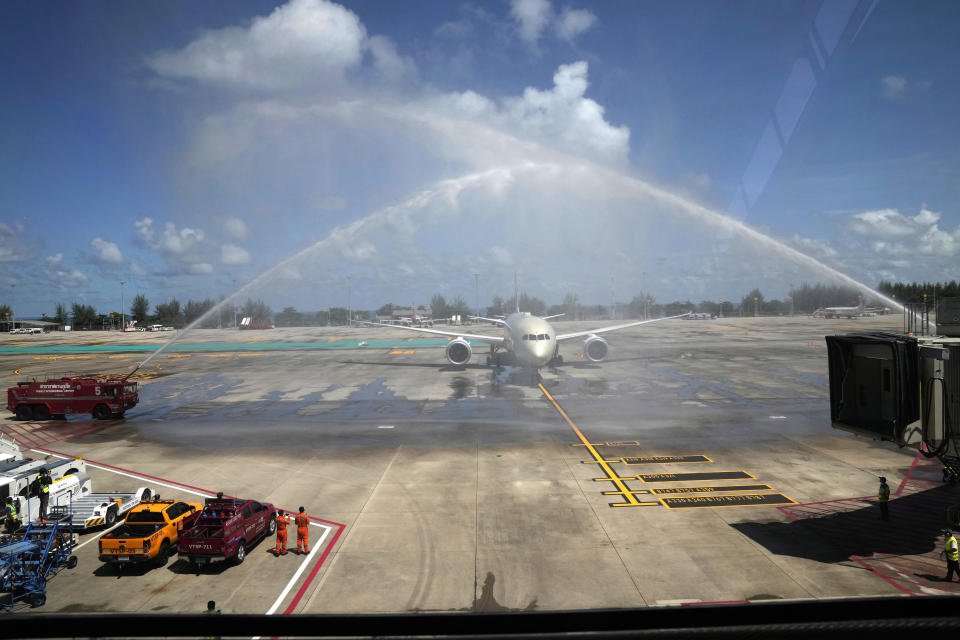 A flight from Abu Dhabi carrying the first group of international tourists to Phuket is ceremoniously showered with water as it arrives at the airport in Phuket, Thailand, Thursday, July 1, 2021. Starting Thursday, Thailand is welcoming back international visitors - as long as they are vaccinated - to its famous southern resort island of Phuket without having to be cooped up in a hotel room for a 14-day quarantine. (AP Photo/Sakchai Lalit)