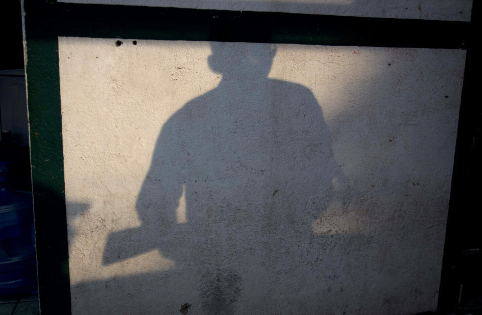 The shadow of an armed man, who belongs to the Self-Defense Council of Michoacan, (CAM), is cast on a wall at a checkpoint set up by the self-defense group at the entrance of Antunez, Mexico, Thursday, Jan. 16, 2014. Vigilantes in violent Michoacan state insist they won't lay down their guns until top leaders of a powerful drug cartel are arrested, defying government orders as federal forces try to regain control in a lawless region plagued by armed groups. (AP Photo/Eduardo Verdugo)