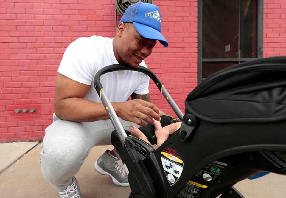 David Montgomery, the new Lions running back talks with his 5-month-old son outside of Fredi's The PizzaMan in Melvindale on Friday, June 16, 2023.