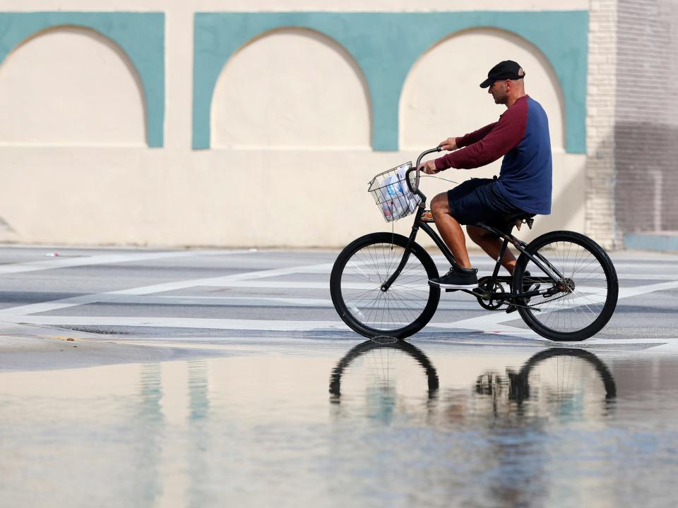 A man riding his bicycle during a day of high tide flooding in Florida.