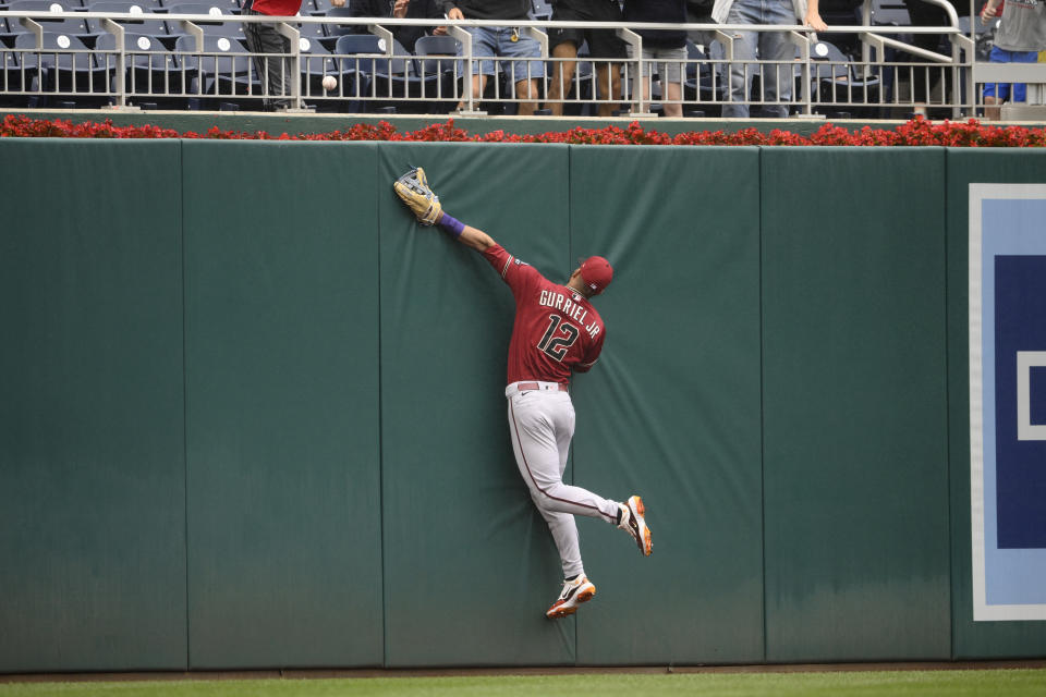 Arizona Diamondbacks left fielder Lourdes Gurriel Jr. slams into the wall as he tries for a ball hit by Washington Nationals' Lane Thomas for a home run during the third inning of a baseball game, Thursday, June 22, 2023, in Washington. (AP Photo/Nick Wass)