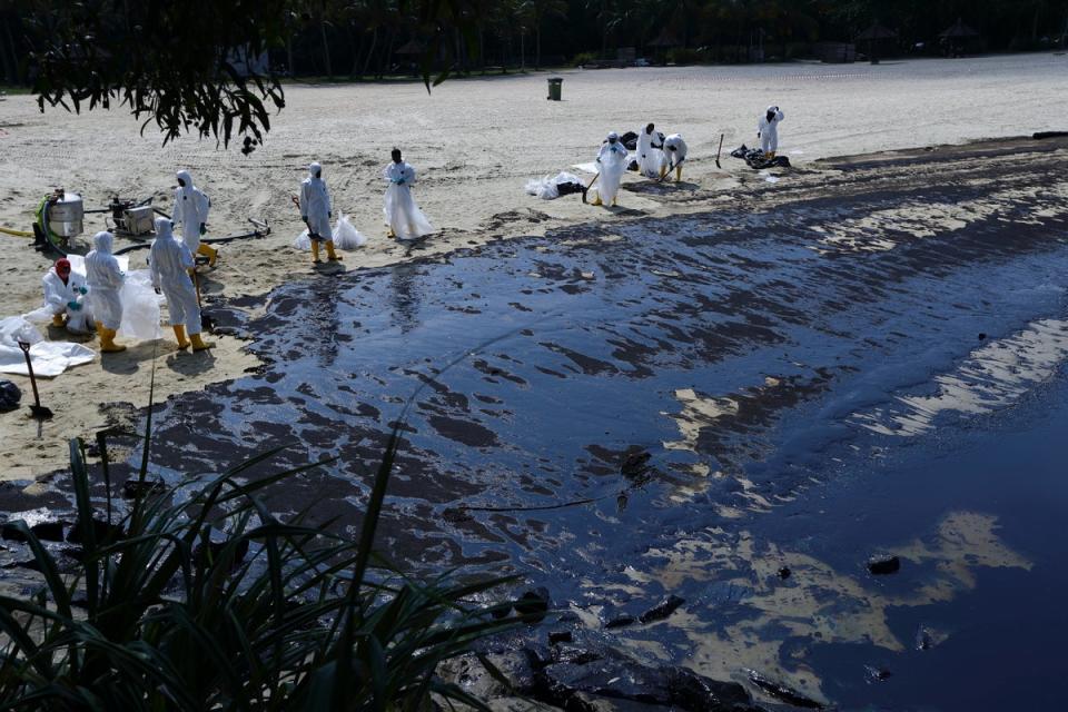 Workers clean oil spill along Sentosa's Tanjong Beach area in Singapore (AP)