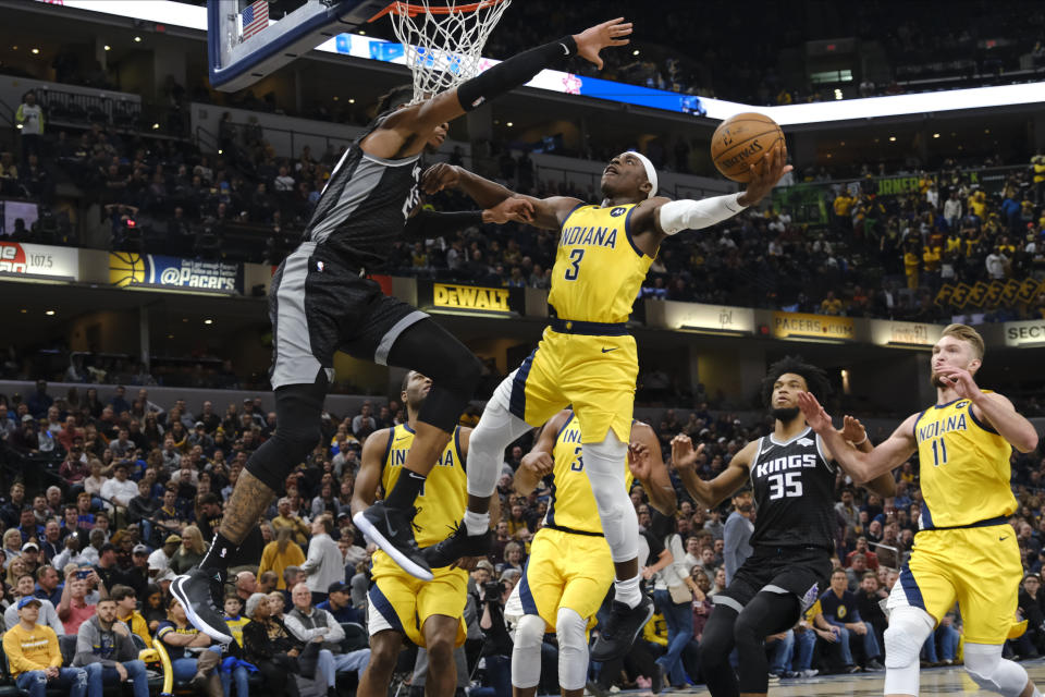 Indiana Pacers guard Aaron Holiday (3) shoots around Sacramento Kings forward Richaun Holmes (22) during the second half of an NBA basketball game in Indianapolis, Friday, Dec. 20, 2019. The Pacers won 119-105. (AP Photo/AJ Mast)