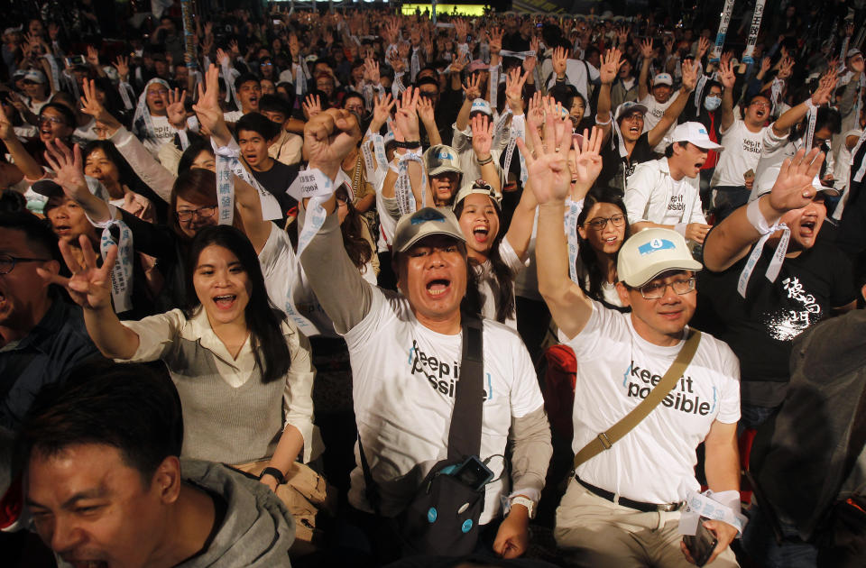 Supporters of Taipei city mayor and city mayoral candidate Ko Wen-je cheer in Taipei, Taiwan, Saturday, Nov. 24, 2018. Taiwan's ruling party suffered a major defeat Saturday in local elections seen as a referendum on the administration of the island's independence-leaning president amid growing economic and political pressure from China. (AP Photo/Chiang Ying-ying)