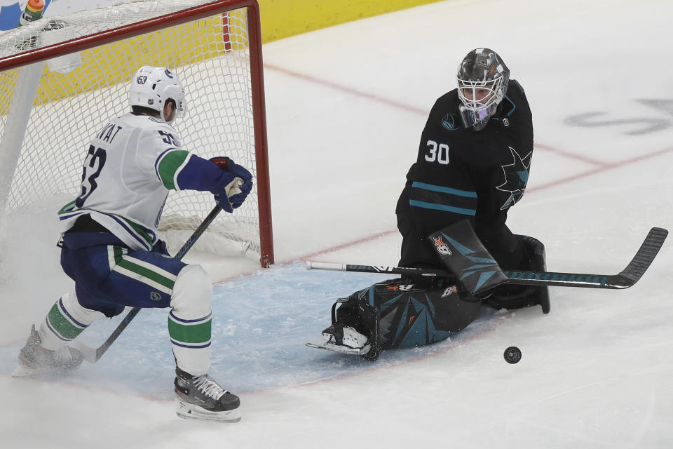 San Jose Sharks goaltender Aaron Dell (30) defends the net against Vancouver Canucks center Bo Horvat (53) during the third period of an NHL hockey game in San Jose, Calif., Saturday, Dec. 14, 2019. (AP Photo/Jeff Chiu)