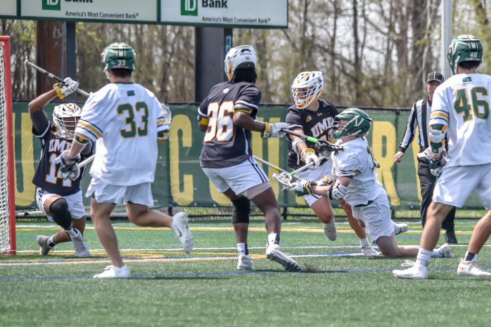 UVM's David Closterman makes a goal after being checked to the ground during the Catamounts' America East Championship game vs the Retrievers at UVM's Virtue Field.