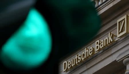 FILE PHOTO: A green traffic light is seen next to the logo of Germany's largest business bank, Deutsche Bank in Frankfurt, Germany, October 27, 2016. REUTERS/Kai Pfaffenbach/File Photo