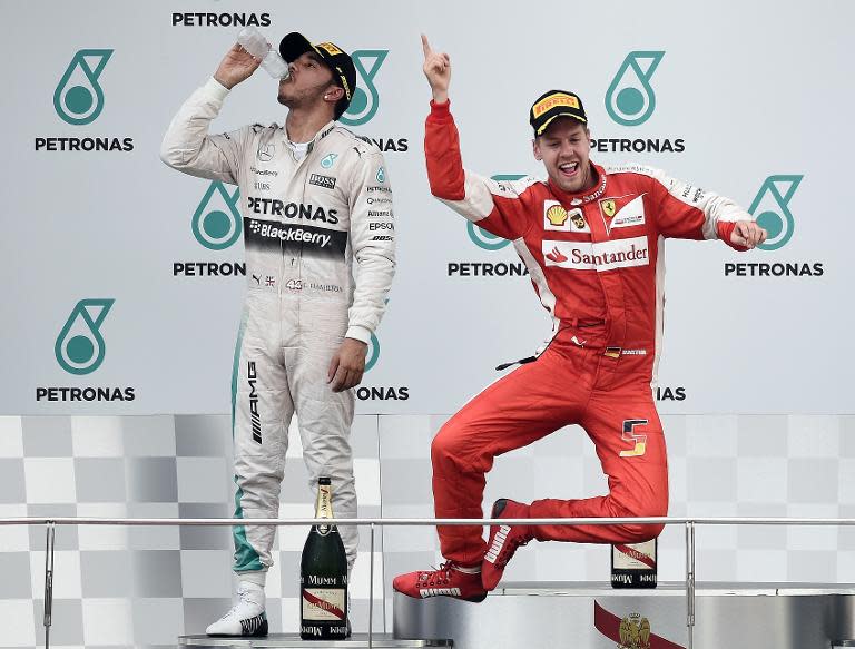 Ferrari's Sebastian Vettel (R) celebrates winning the Malaysian Grand Prix ahead of Lewis Hamilton (L) on March 29, 2015