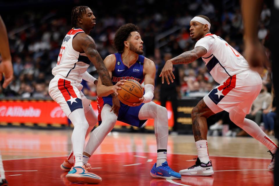 Pistons guard Cade Cunningham dribbles the ball as Wizards guard Delon Wright, left, and center Daniel Gafford defend during the first half on Tuesday, Oct. 25, 2022, in Washington.