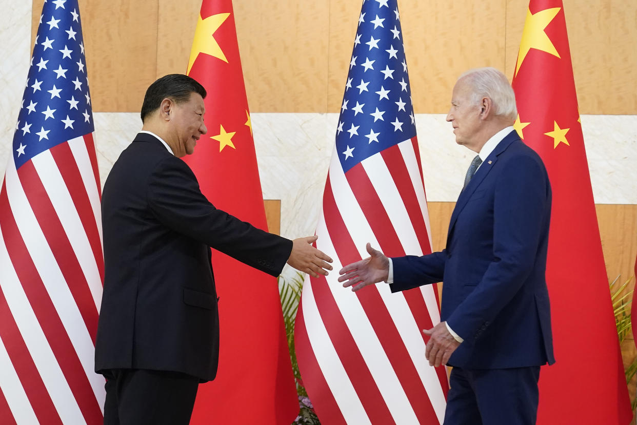 President Biden and Chinese President Xi Jinping with their arms extended for a handshake. 