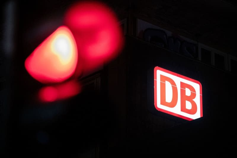 The Deutsche Bahn logo can be seen behind a red traffic light. Fabian Strauch/dpa
