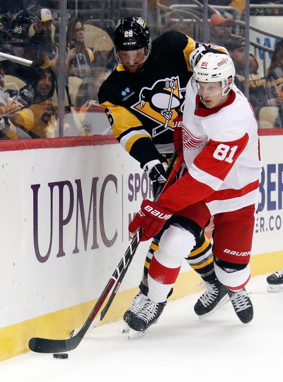Pittsburgh Penguins defenseman Jeff Petry (26) and Detroit Red Wings left wing Dominik Kubalik (81) battle to control the puck during a preseason game at PPG Paints Arena, Sept. 22, 2022.