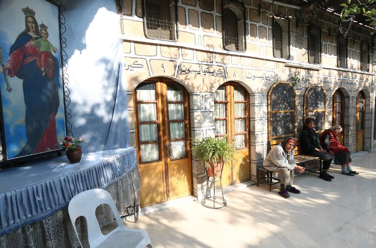 Syrian Christians sit in the courtyard at the Saint Elias centre for the elderly in the rebel-held side of Aleppo on November 18, 2014