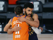 Indiana Pacers' Naz Mitrou-Long, rear, and Phoenix Suns' Ricky Rubio (11) hug at the end of an NBA basketball game Thursday, Aug. 6, 2020, in Lake Buena Vista, Fla. (Kevin C. Cox/Pool Photo via AP)