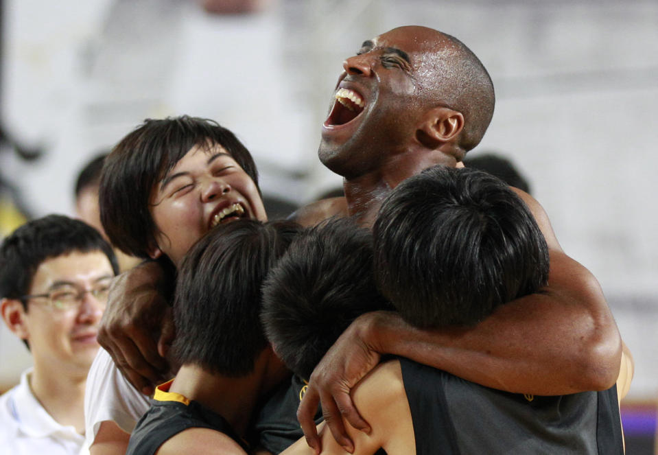 NBA's Los Angeles Lakers Kobe Bryant embraces South Korean students in his basketball clinic for youth in Seoul, South Korea, Thursday, July 14, 2011. Bryant is in Seoul during his five-Asian cities tour. (AP Photo/Lee Jin-man)