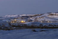 Lights illuminate a coal mine at twilight, Thursday, Jan. 13, 2022, in Kemmerer, Wyo. With the nearby coal-fired Naughton Powerplant being decommissioned in 2025, the fate of the coal mine and its workers is uncertain. (AP Photo/Natalie Behring)