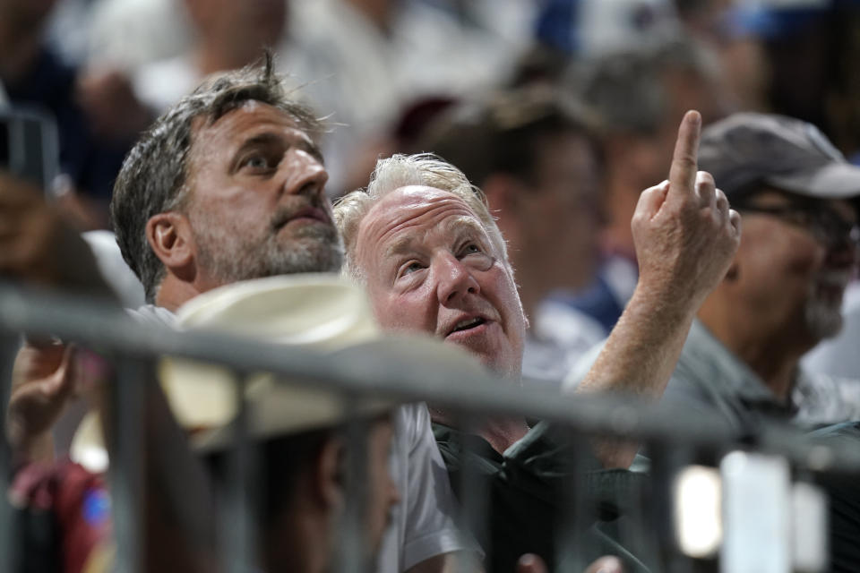 Actor Timothy Busfield, right, watches during a baseball game between the Cincinnati Reds and Chicago Cubs at the Field of Dreams movie site, Thursday, Aug. 11, 2022, in Dyersville, Iowa. (AP Photo/Charlie Neibergall)