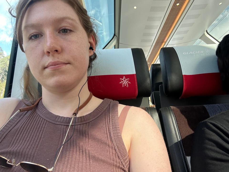 woman sitting in train seat with someone else's shoulder about two inches away