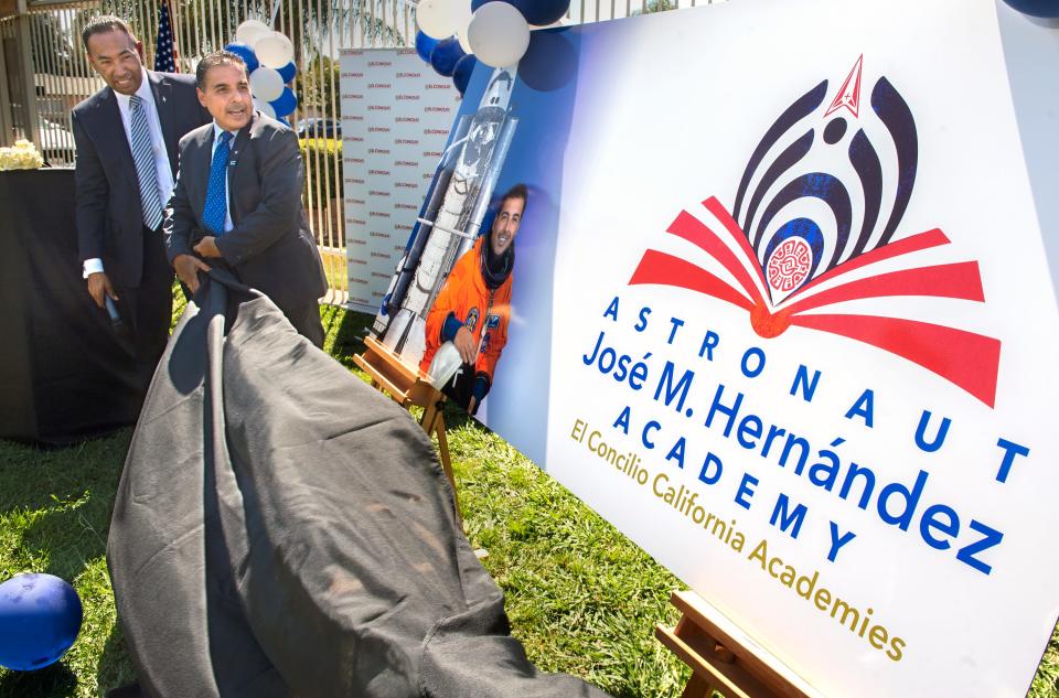 El Concilio president and CEO Jose Rodriguez, left, and Jose Hernandez unveil a sign at the dedication ceremony for his namesake school, the Astronaut Jose M. Hernandez Academy in Stockton.  