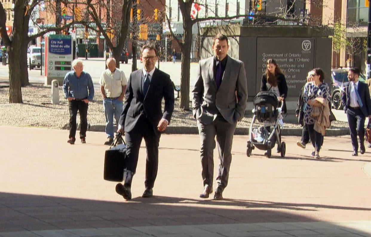 Former Ottawa firefighter Eric Einagel, right, enters the Ottawa courthouse with his lawyer Dominic Lamb on the first day of his trial. Also facing trial is Ottawa Fire Services Capt. Greg Wright. (Patrick Louiseize/CBC - image credit)