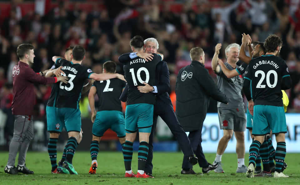 Mark Hughes celebrates with the Southampton squad following their win at Swansea