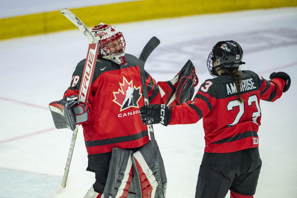 Canada goaltender Emerance Maschmeyer (38) and teammate Erin Ambrose (23) celebrate the team's win over the United States in a Rivalry Series hockey game Friday, Feb. 9, 2024, in Regina, Saskatchewan. (Liam Richards/The Canadian Press via AP)