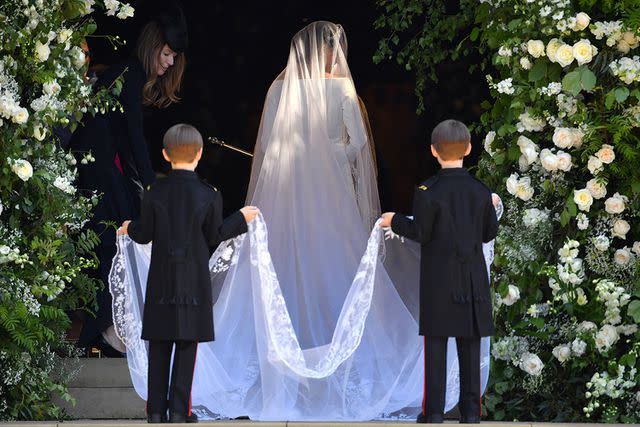 <p>Ben Stansall - WPA Pool/Getty</p> Clare Waight Keller assisting Meghan Markle with her dress on her wedding day