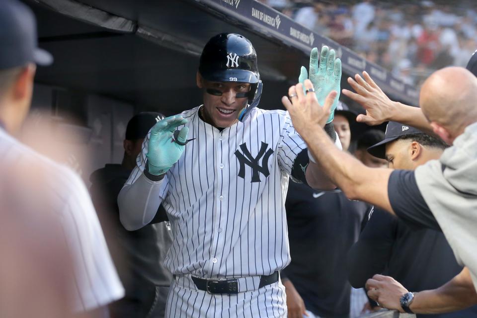 New York Yankees center fielder Aaron Judge (99) celebrates his solo home run against the Houston Astros with teammates in the dugout during the third inning at Yankee Stadium.