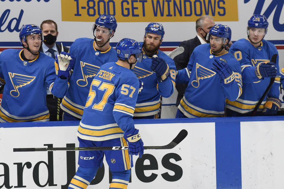 St. Louis Blues' David Perron (57) is congratulated by teammates after scoring a goal against the Los Angeles Kings during the second period of an NHL hockey game Saturday, Jan. 23, 2021, in St. Louis. (AP Photo/Joe Puetz)