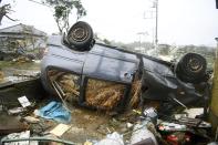An overturned car lies on the ground following a strong wind in Ichihara, Chiba, near Tokyo Saturday, Oct. 12, 2019. Under gloomy skies, a tornado ripped through Chiba on Saturday.(Kyodo News via AP)