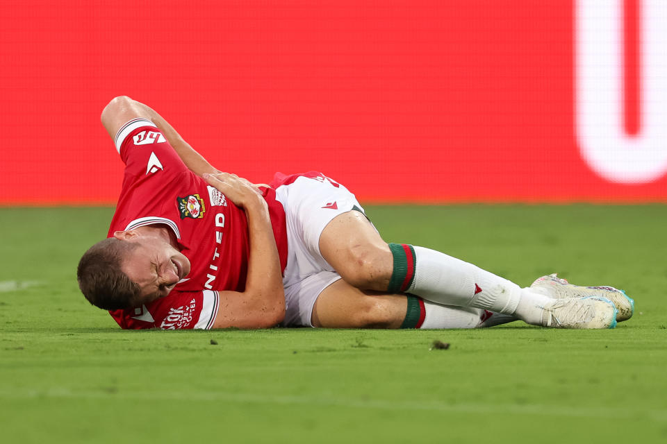 Paul Mullin went down with an injury 12 minutes into Wrexham's match with Manchester United. (Photo by Matthew Ashton - AMA/Getty Images)