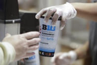 A worker hands a drink to a customer before a NCAA college basketball game between Northwestern and Minnesota at the Big Ten Conference tournament, Wednesday, March 11, 2020, in Indianapolis. (AP Photo/Darron Cummings)