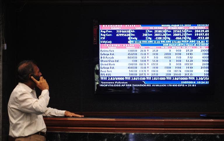 A Pakistani stockbroker monitors the latest share prices at the Karachi Stock Exchange on August 11, 2014