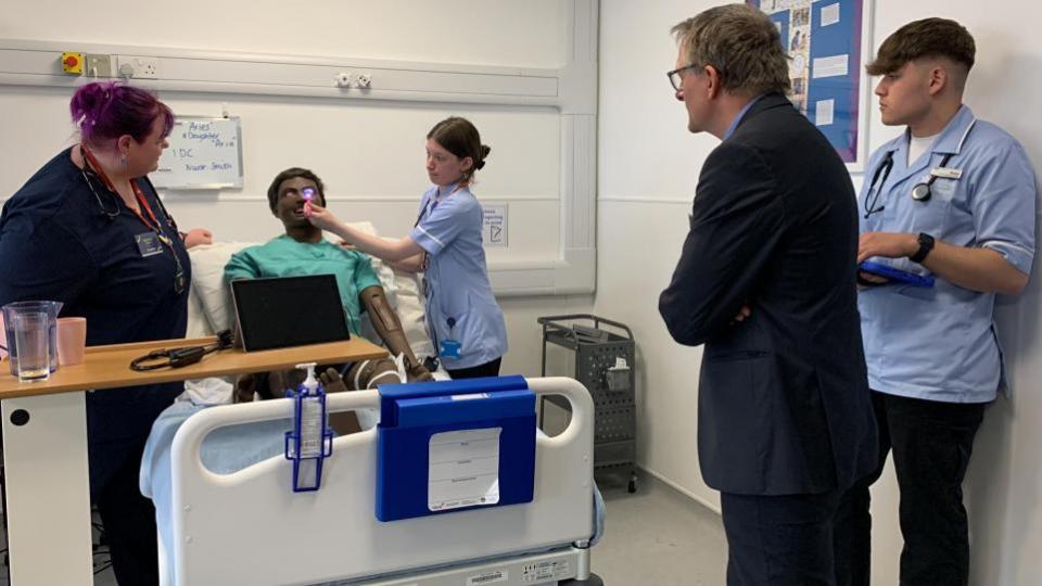 Swindon Advertiser: el Dr. Michael Mosley observa a los estudiantes de T-Level examinar los ojos de un maniquí de Blossom Ward