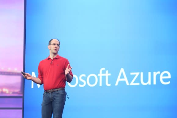 Microsoft executive standing in front of blue Microsoft Azure sign