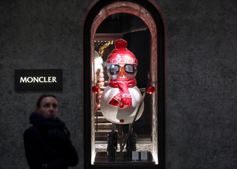 A woman walks past Moncler's flagship store in Montenapoleone street downtown Milan