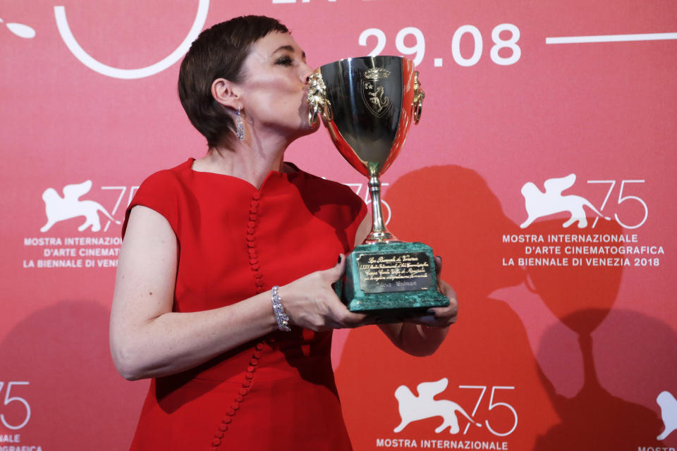 File - Actress Olivia Colman kisses the Coppa Volpi Best Actress award for 'The Favourite' at the Venice Film Festival. The 77th Venice Film Festival will kick off on Wednesday, Sept. 2, 2020, but this year's edition will be unlike any others. Coronavirus restrictions will mean fewer Hollywood stars, no crowds interacting with actors and other virus safeguards will be deployed. (AP Photo/Kirsty Wigglesworth, File)