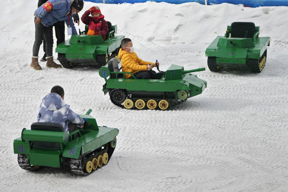 Children ride on toy tanks in the snow at a public park in Beijing, Thursday, Jan. 19, 2023. China on Thursday accused "some Western media" of bias, smears and political manipulation in their coverage of China's abrupt ending of its strict "zero-COVID" policy, as it issued a vigorous defense of actions taken to prepare for the change of strategy. (AP Photo/Andy Wong)