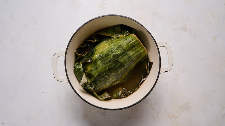 preparing kalua pork with banana leaves