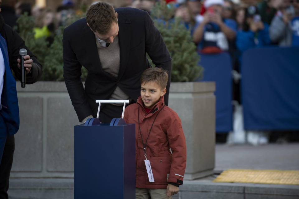 Dirk Nowitzki speaks to his son, Max, during the "All Four One" statue ceremony in front of the American Airlines Center in Dallas, Sunday, Dec. 25, 2022. (AP Photo/Emil T. Lippe)