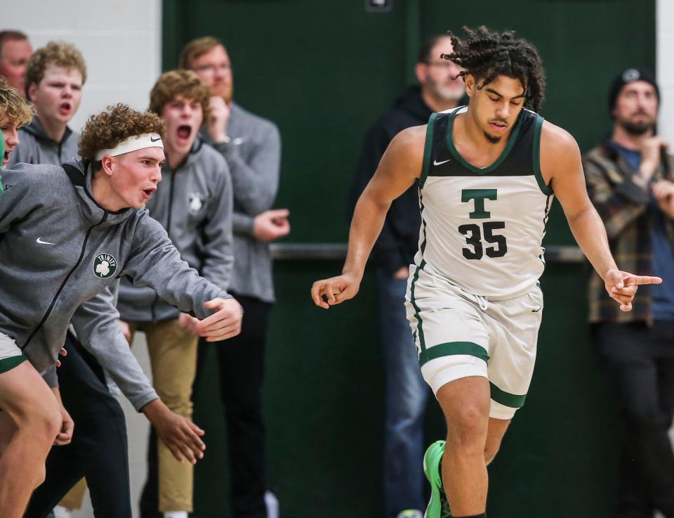 Trinity's CJ Walls signifies his three-point goal to the cheers of the Rocks' bench in the second half at Trinity High School in St. Matthews Tuesday night. Trinity would win 54-49. Nov. 29, 2022