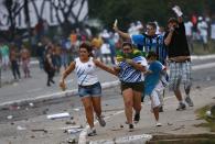 RNPS - PICTURES OF THE YEAR 2013 - A family with soccer match tickets runs for cover as they come between law enforcement troops and protesters during a demonstration outside the stadium before the Confederations Cup soccer match between Nigeria and Uruguay in Salvador June 20, 2013. REUTERS/Kai Pfaffenbach (BRAZIL - Tags: SPORT SOCCER CIVIL UNREST TPX)