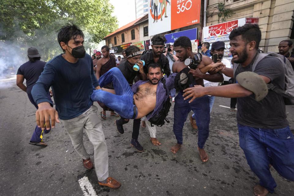 An injured student is carried by colleagues as police fire tear gas and water cannons to disperse protesting members of the Inter University Students Federation during an anti government protest in Colombo, Sri Lanka, May 19, 2022. The image was part of a series of images by Associated Press photographers that was a finalist for the 2023 Pulitzer Prize for Breaking News Photography. (AP Photo/Eranga Jayawardena)