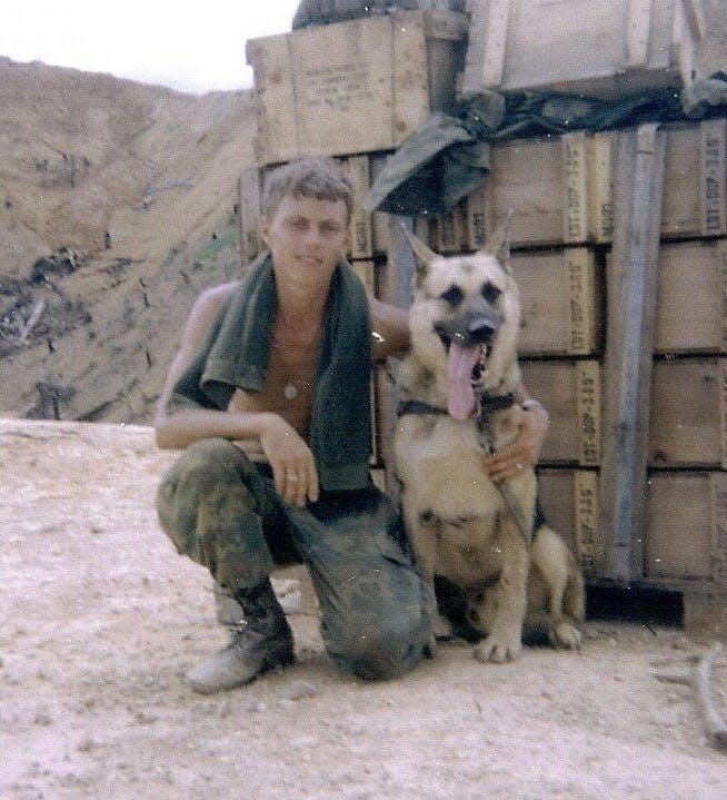 John Meeks and his U.S. Army scout dog Artus in 1970, taken at Firebase Birmingham in Vietnam after Meeks' first mission with Artus. Artus was killed in Vietnam and his name is on the memorial wall at the Michigan War Dog Memorial in Lyon Township.