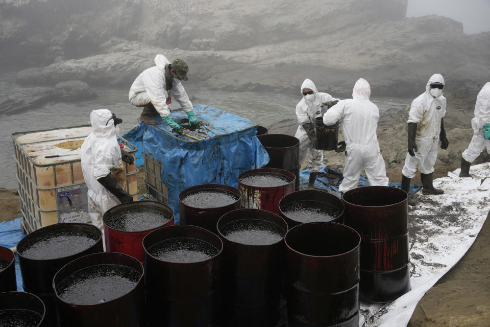 FILE - Workers remove oil waste from Cavero Beach in the Ventanilla district of Callao, Peru, Jan. 21, 2022, following the Repsol oil spill caused by a tsunami from the eruption of an underwater volcano near Tonga. Peru has characterized the Jan. 15 spill as its "worst ecological disaster." (AP Photo/Martin Mejia, File)