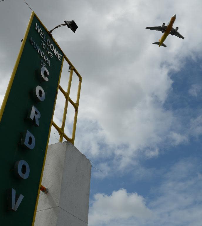 A passenger plane flies over Ibabao village, Cebu provnce, in central Philippines, on January 22, 2014