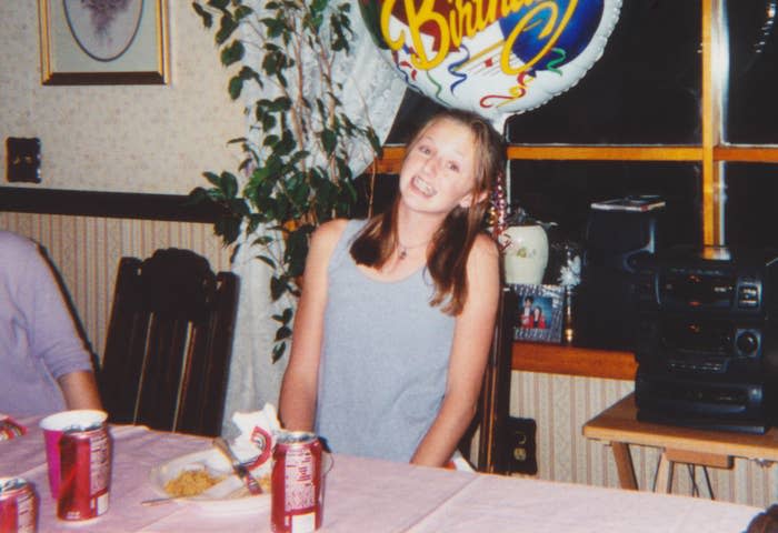 teen next to a chunky stereo at a kitchen table celebrating their birthday