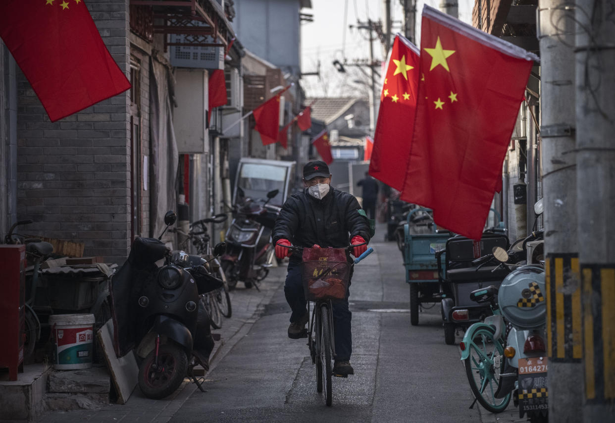 Un hombre chino usa una máscara protectora mientras conduce su bicicleta en un callejón el 31 de enero de 2020 en Beijing. (Photo by Kevin Frayer/Getty Images)